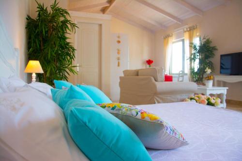 a bedroom with a bed with blue pillows at Ideales Resort in Trapezaki