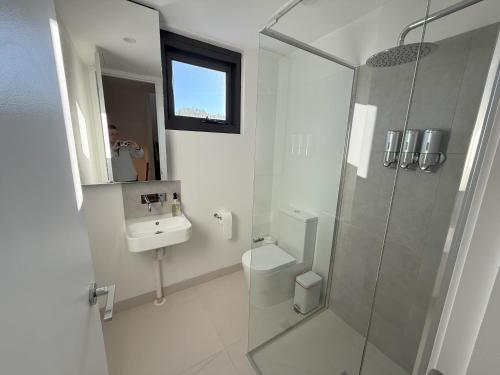 a bathroom with a shower and a toilet and a sink at Ski Lift Access - Modern 3BR Chalet - Fireplace in Mount Buller