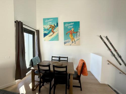 a dining room with a table and two posters on the wall at Ski Lift Access - Modern 3BR Chalet - Fireplace in Mount Buller