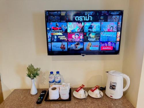a tv hanging on a wall with bottles of water at Bensri residence pattaya in Pattaya South