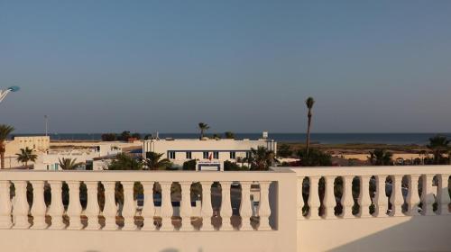 a white balcony with a view of the beach at Ahla in Mahires