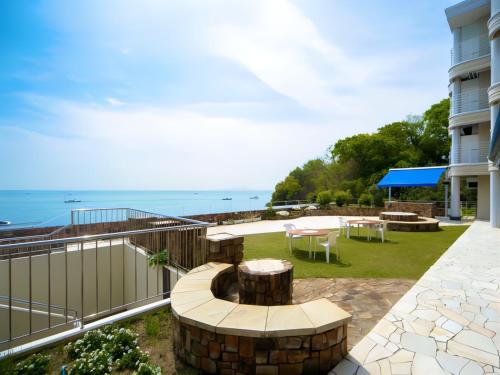 a balcony with a patio with a view of the ocean at LiVEMAX RESORT Setouchi Sea Front in Tatsuno