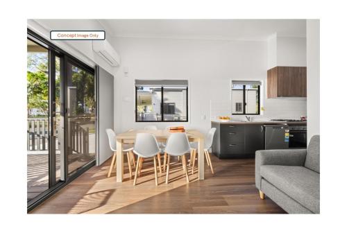 a kitchen and a dining room with a table and chairs at Discovery Parks - Clare in Clare