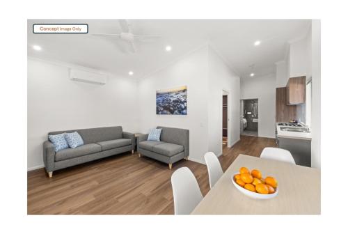 a living room with a couch and a table with oranges at Discovery Parks - Clare in Clare