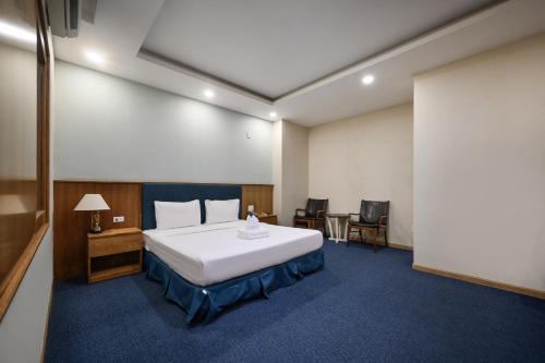 a hotel room with a bed and a table and chairs at Sunshine Airport Hotel in Ho Chi Minh City