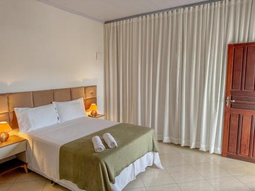 ein Schlafzimmer mit einem Bett mit zwei Handtüchern darauf in der Unterkunft Casa na prainha de Mambucaba. Uma quadra do mar. in Paraty