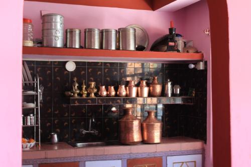 a kitchen with a shelf with pots and pans at Laxmi Homestay in Tānsing