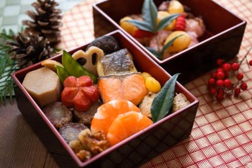 twee dozen gevuld met verschillende soorten voedsel op een tafel bij LiVEMAX RESORT izukogen in Ito