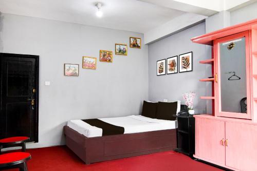 a bedroom with a bed and a red carpet at Super Hotel O Ghoom Formerly Aps Homestay in Darjeeling