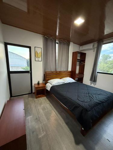 a bedroom with a large bed and two windows at Bunker593 Inn in Tena