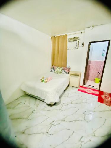 a bedroom with a bed and a marble floor at Budget-StudioRoom-Panabo-Homestay in Panabo