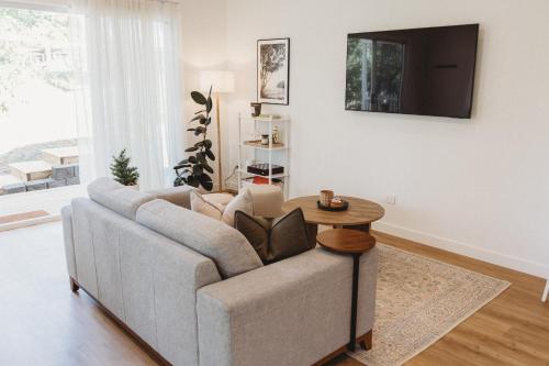 a living room with a couch and a table at Private & Stylish Hinterland Cottage in Gold Coast