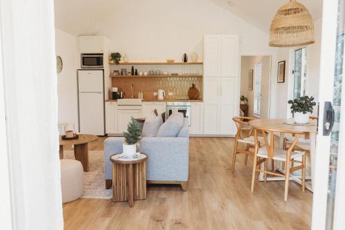a living room with a blue couch and a table at Private & Stylish Hinterland Cottage in Gold Coast