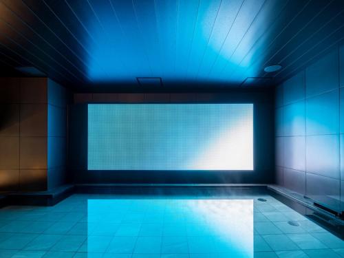an empty room with a blue light on the wall at CROSS Life Hakata Tenjin in Fukuoka