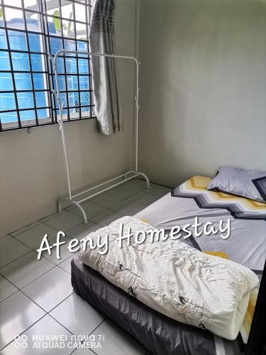 a bedroom with a bed in a room with a window at Afeny Homestay in Tawau