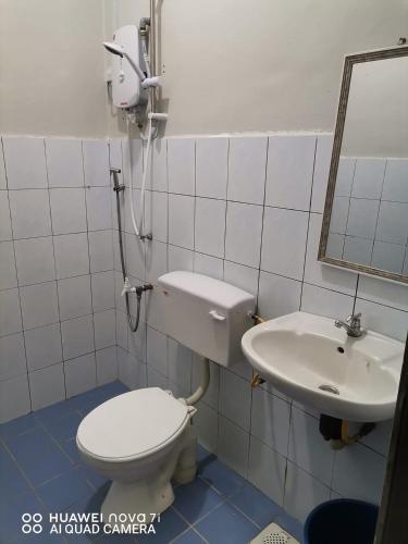 a bathroom with a toilet and a sink at Afeny Homestay in Tawau