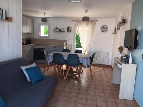 une cuisine et un salon avec une table et des chaises dans l'établissement Maison plain-pied au calme, proche plage et commerces, animaux bienvenus sur demande - FR-1-476-91, à La Faute-sur-Mer
