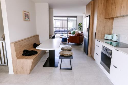 a kitchen with a white table and a table in a room at Family Friendly - Close to new stadium in Christchurch