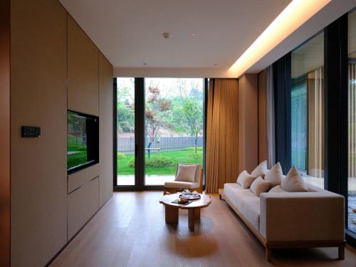 a living room with a white couch and a table at Ruolinqiao Valley Garden Hotel in Tiantai