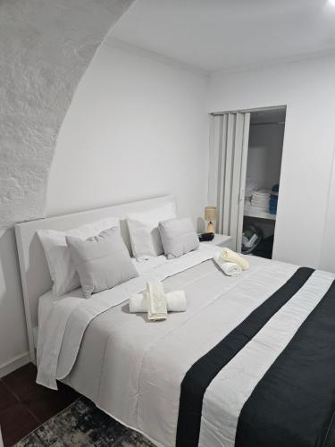 a large white bed with two towels on it at Casa da Mina in Ponta Delgada