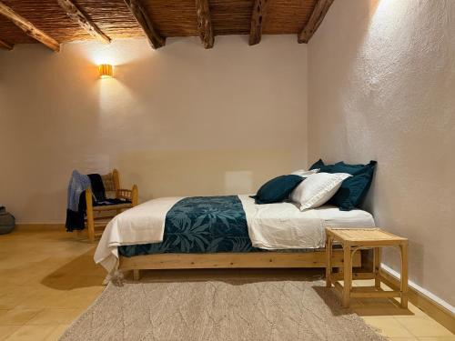 a bedroom with a bed with blue pillows at Serenity Mogador in Essaouira
