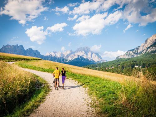 a man and a woman riding a bike down a dirt road at Holiday Home in Veneto's Prosecco Hills in Farra di Soligo