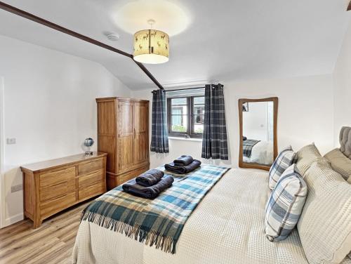 a bedroom with a bed and a mirror at Byre Cottage Dulverton in Dulverton