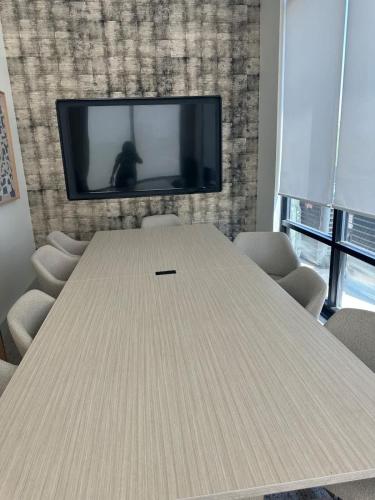 a conference room with a table and a tv at Pinky in Austin