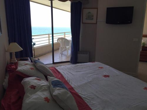a bedroom with a bed with a view of the ocean at Condominio San Alfonso del Mar in Algarrobo
