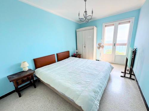 une chambre avec un grand lit aux murs bleus dans l'établissement BANYULS-SUR-MER, appartement T2 avec ascenseur proche plage - FR-1-309-102, à Banyuls-sur-Mer