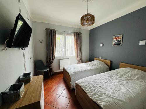 a bedroom with two beds and a flat screen tv at Maison à Argelès Plage, 50m de la Mer, WIFI, Clim, Terrasse, Parking Privé - FR-1-309-322 in Argelès-sur-Mer