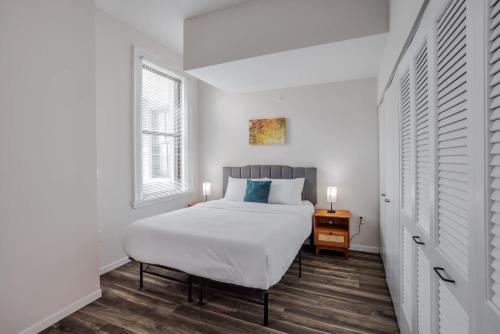a white bedroom with a bed and a window at Stunning CozySuites Sky Central #1 in Cincinnati