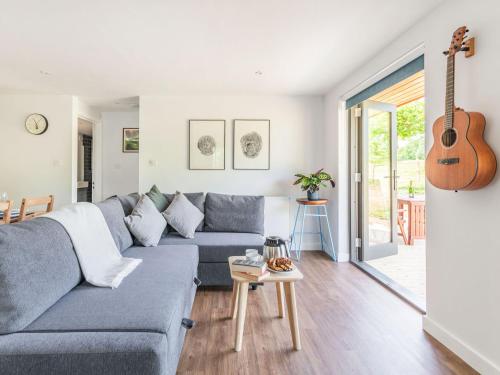 a living room with a blue couch and a guitar at Culver Croft in Chiddingstone