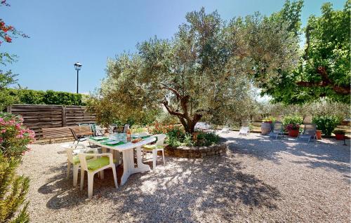 une table et des chaises assises sous un arbre dans l'établissement 2 Bedroom Gorgeous Apartment In Caromb, à Caromb