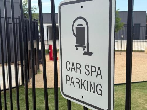 a sign that reads car spa parking in front of a fence at Pink Couture in Austin