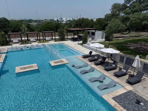 a large swimming pool with chairs and umbrellas at Pink Couture in Austin