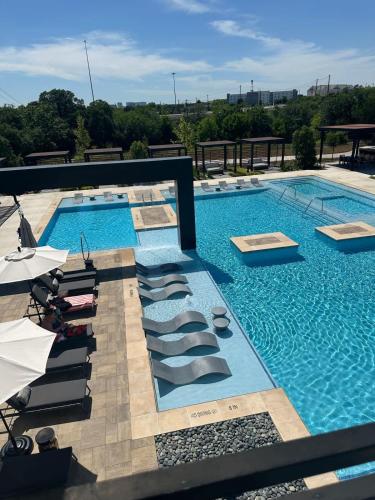 a large swimming pool with lounge chairs next to it at Pink Couture in Austin