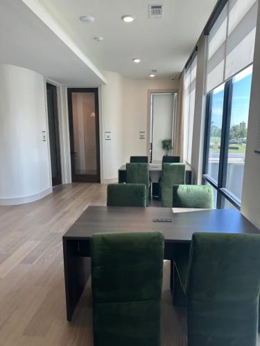 a conference room with a table and green chairs at Pink Couture in Austin