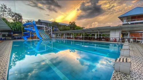 a large swimming pool with a slide in front of a building at El Encanto de Las Marias in Satipo