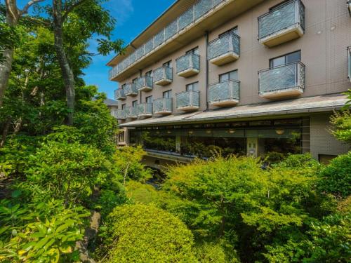 a building with balconies and bushes in front of it at ダイヤモンド鎌倉別邸ソサエティ in Kamakura