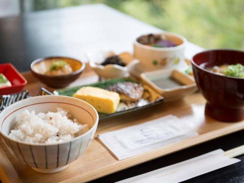 a tray with rice and other bowls of food at ダイヤモンド鎌倉別邸ソサエティ in Kamakura