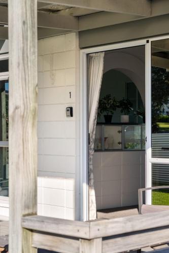 a screened porch with a sliding glass door at Modern 2BR Home in Gisborne