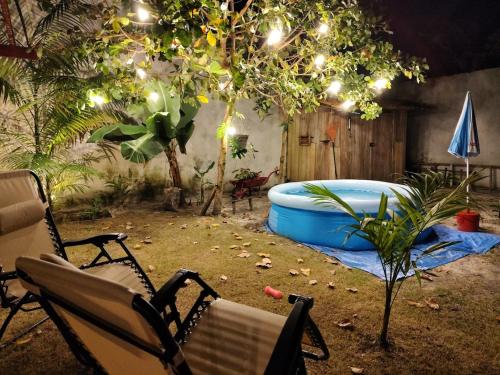 a backyard with a tub and a chair and a tree at Chalé Azul na Praia do Paraíso in Belém