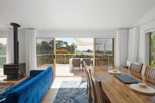 a living room with a blue couch and a table at Ocean Views on Acres - Diamond Beach in Diamond Beach