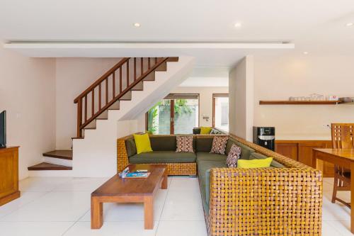 a living room with a couch and a table at Du Ciel Villa by Betterplace in Canggu
