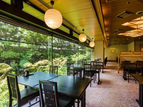 a restaurant with tables and chairs and large windows at ダイヤモンド鎌倉別邸ソサエティ in Kamakura