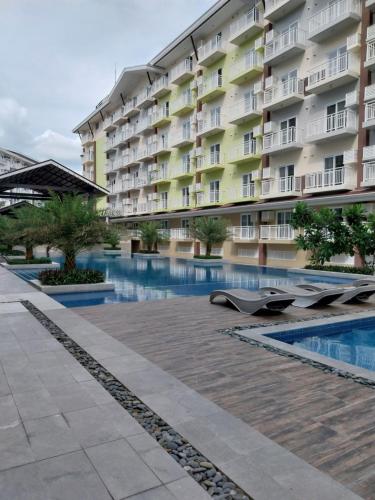 a hotel with a swimming pool in front of a building at Bayay ni Lola in Mactan Cebu International