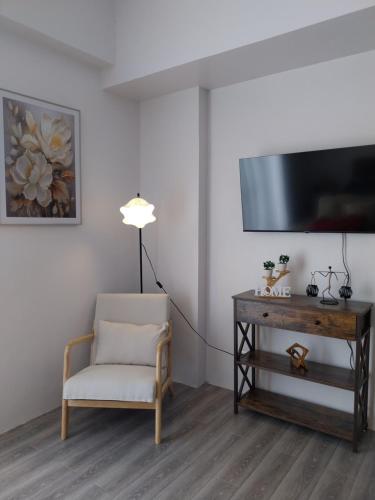 a living room with a tv and a chair and a desk at Bayay ni Lola in Mactan Cebu International