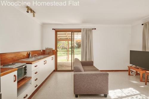 a kitchen with a sink and a living room at Woodbine Homestead in Hallidays Point