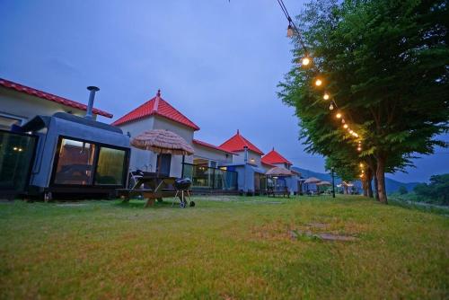 a group of houses with a table and an umbrella at Cheongju Crepas Pension in Cheongju